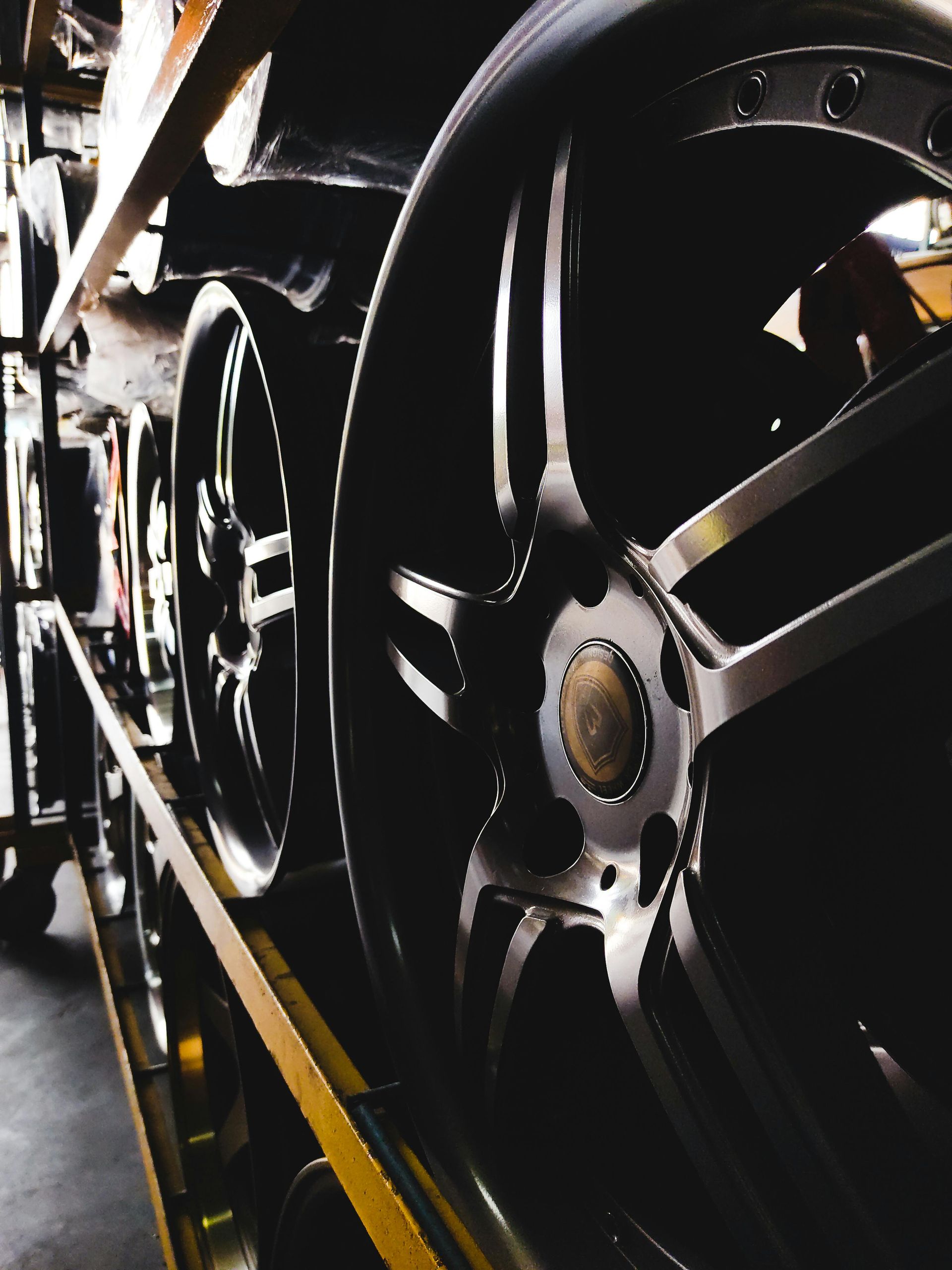 Close-up of a black locomotive wheel and axle on train tracks