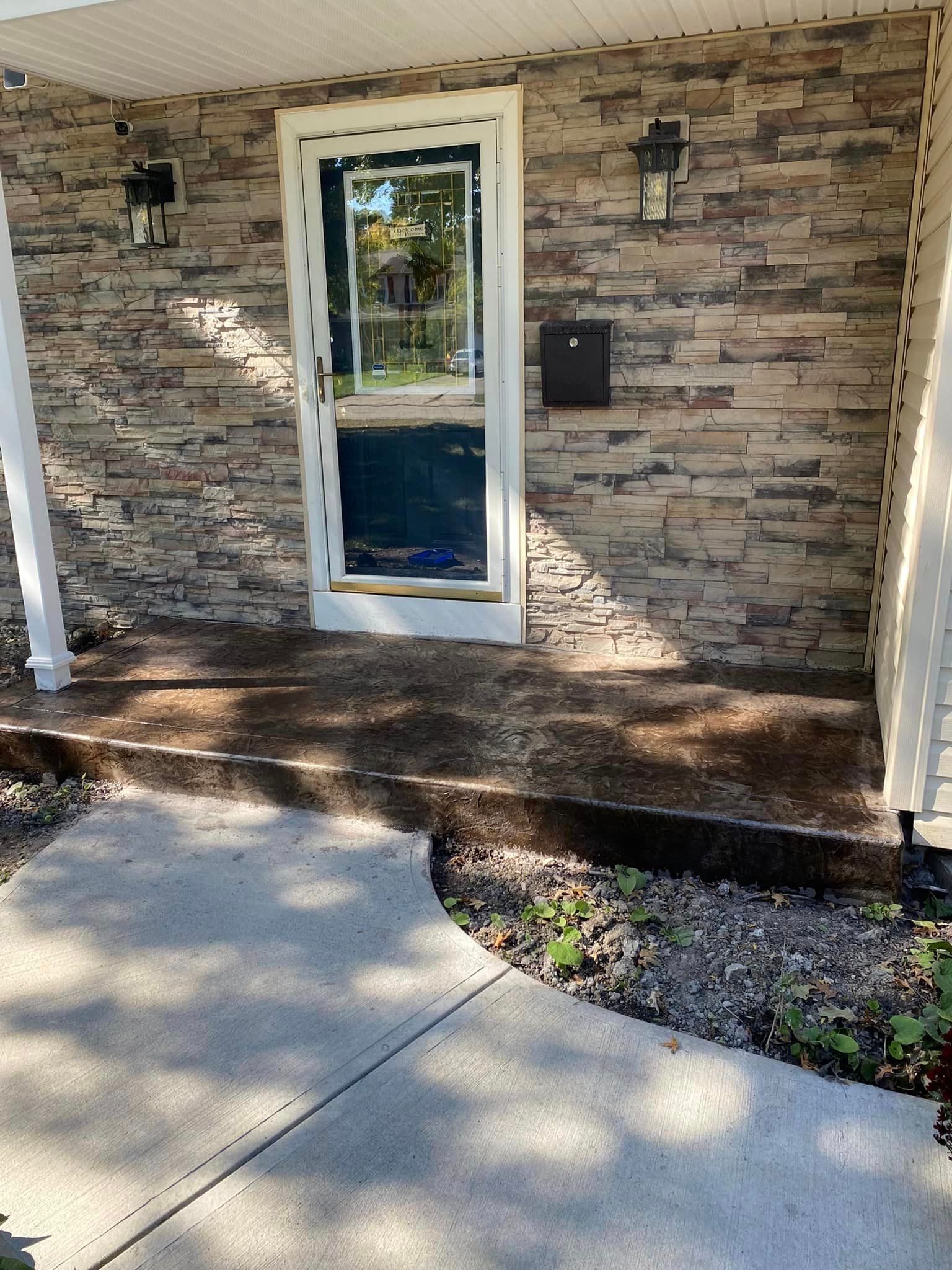 A brick house with a porch and a door.