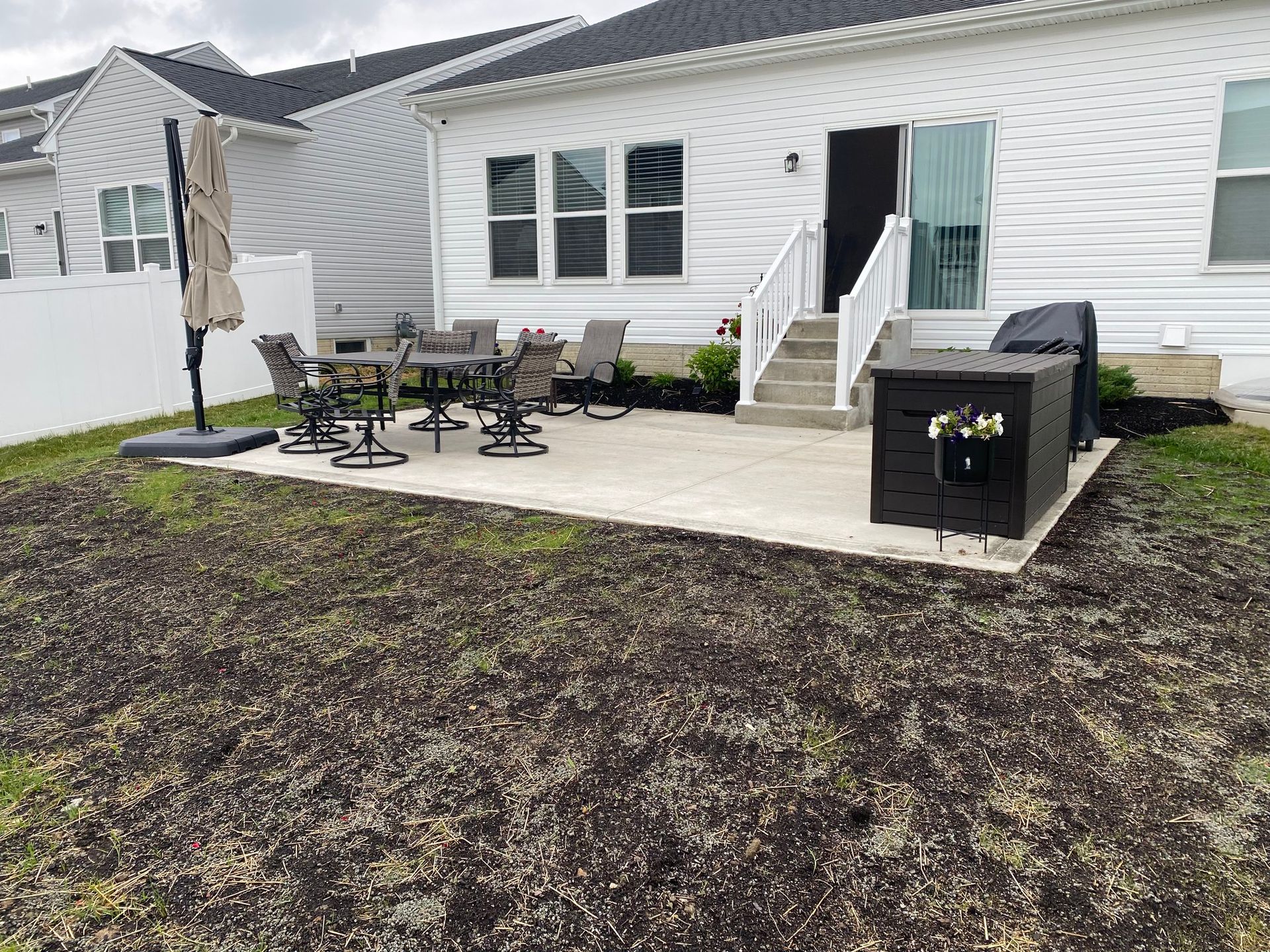 The backyard of a house with a patio and a grill.