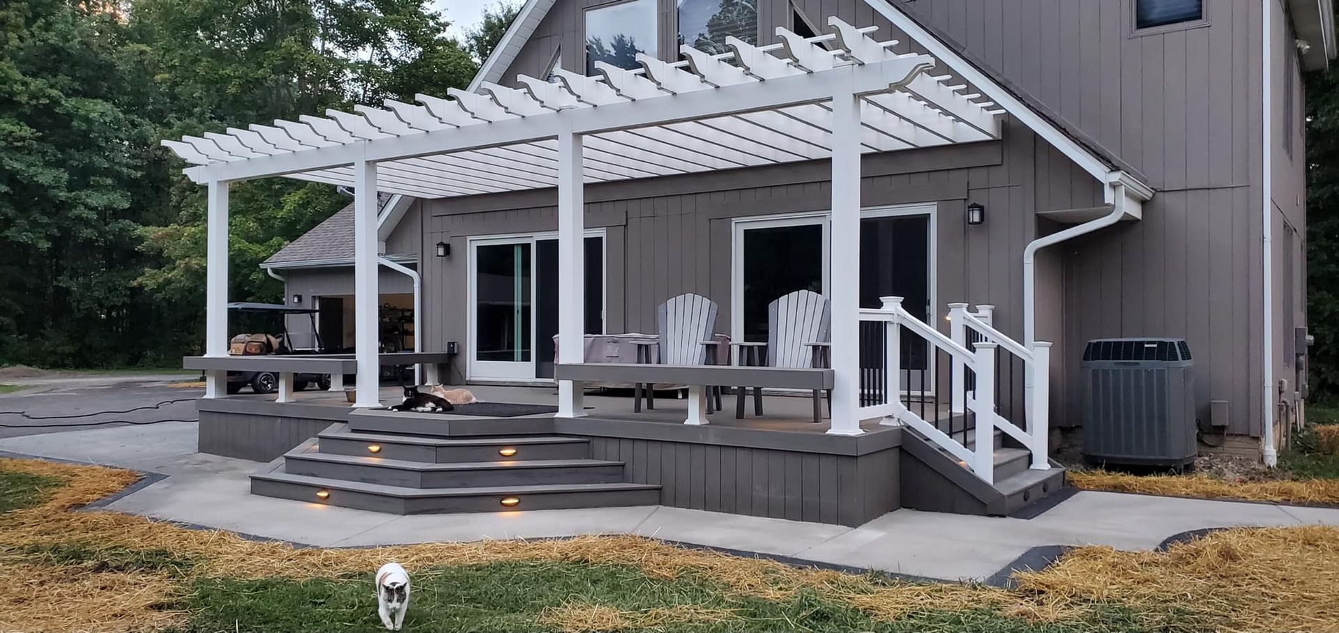 A house with a white pergola on the front porch.