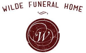 The logo for wilde funeral home is a red seal with the letter w on it.