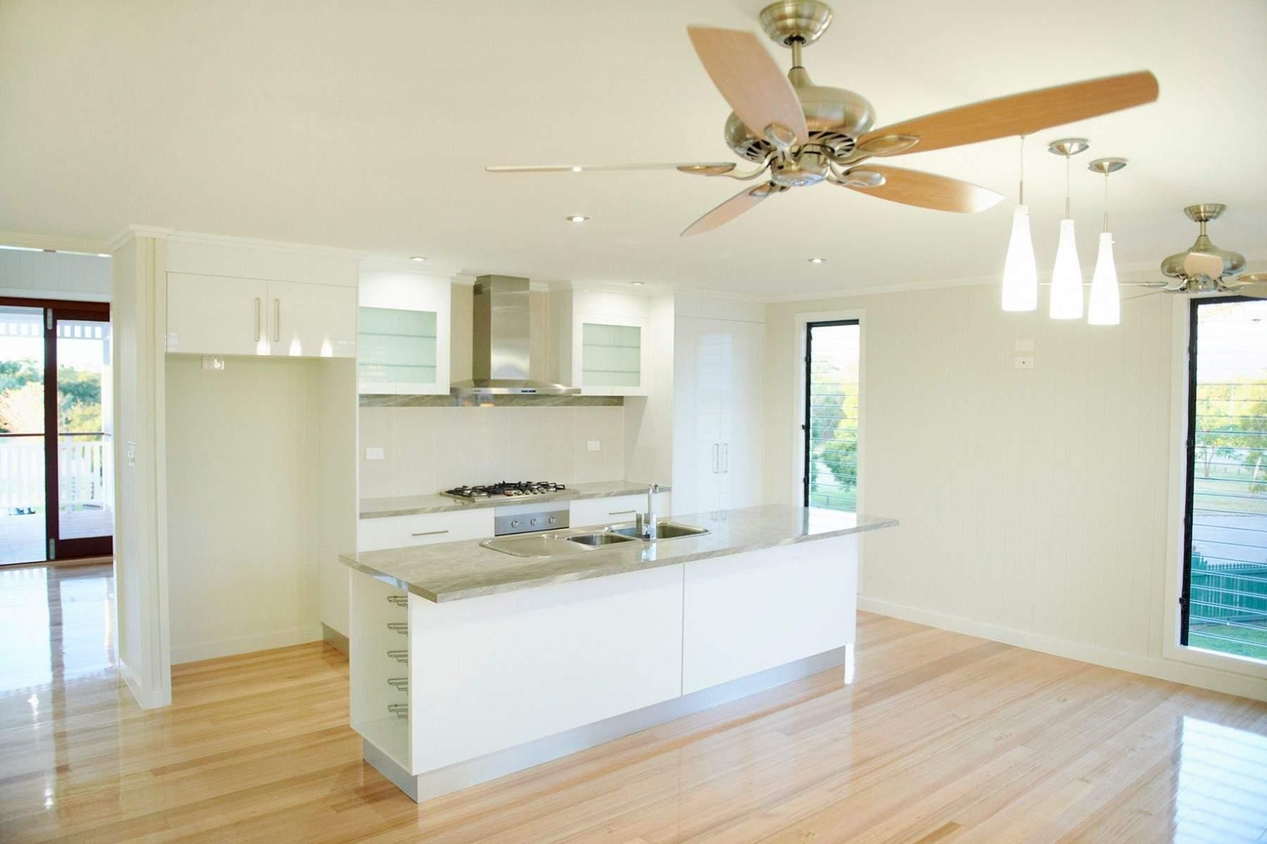 An Empty Kitchen With a Ceiling Fan and Wooden Floors — Pro-Jax Pty Ltd in Bohle, QLD