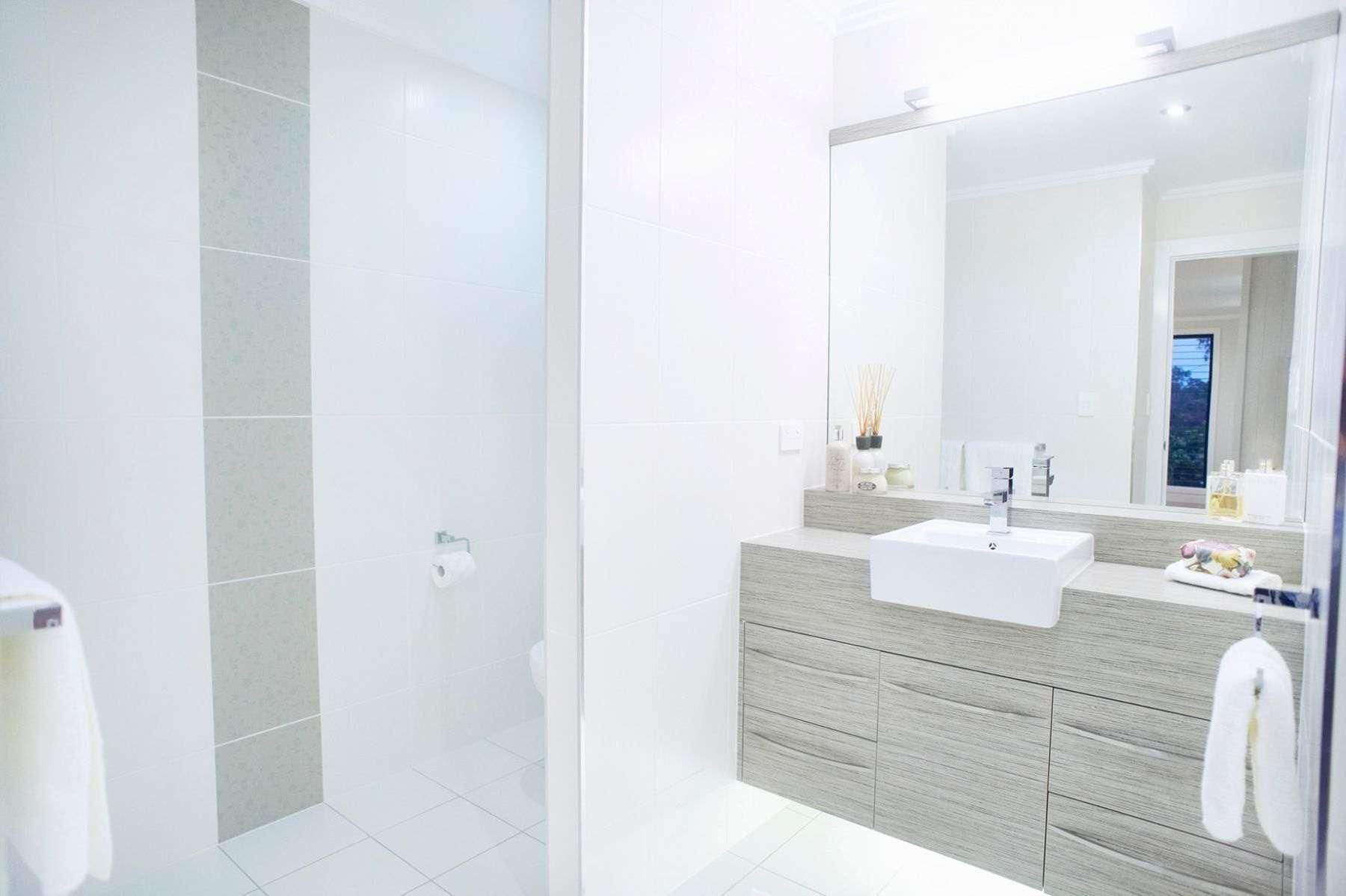 A Bathroom With a Sink, Mirror and Walk in Shower — Pro-Jax Pty Ltd in Bohle, QLD