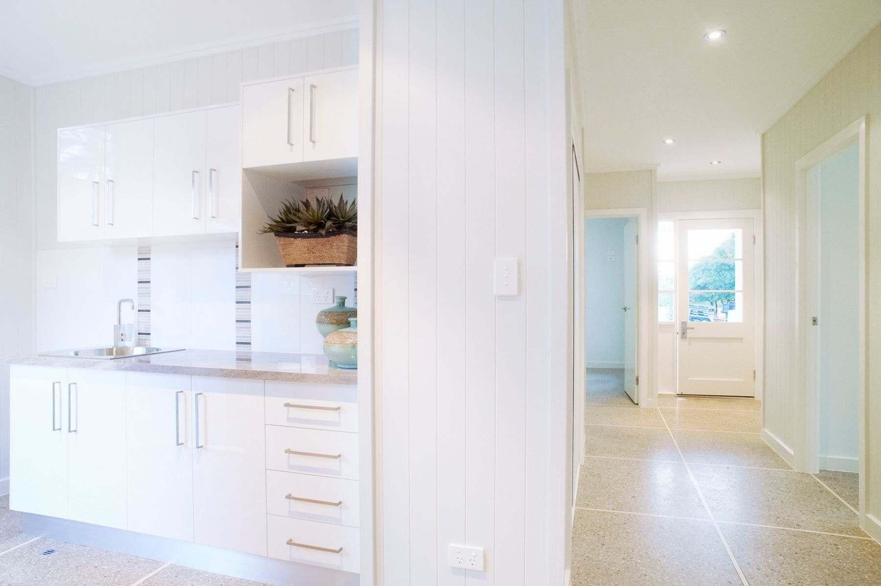 A Kitchen With White Cabinets and a Sink in a House — Pro-Jax Pty Ltd in Bohle, QLD