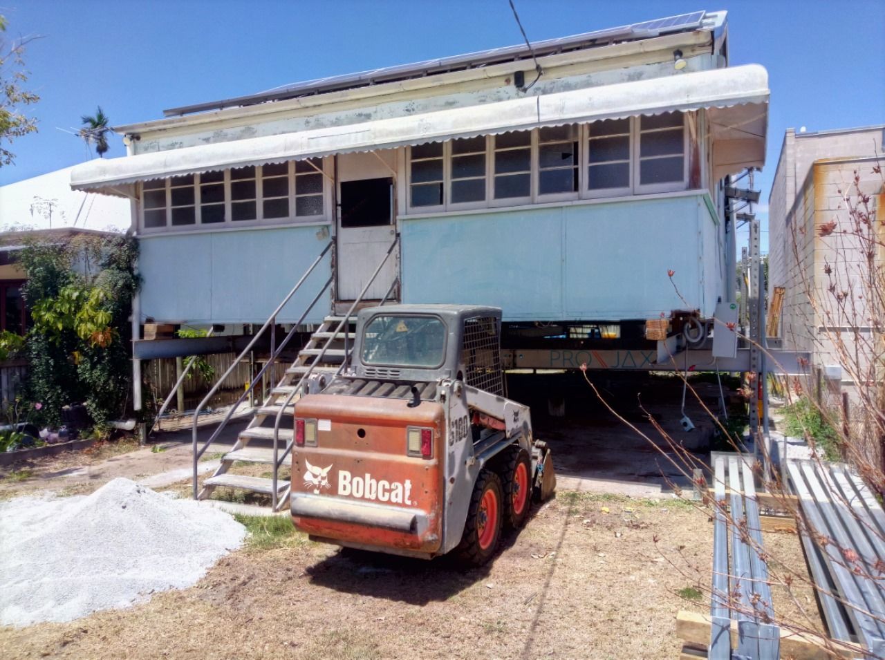 A House on Stilts With a Bobcat Loader in Front, Likely for Construction — Pro-Jax Pty Ltd in Bohle, QLD