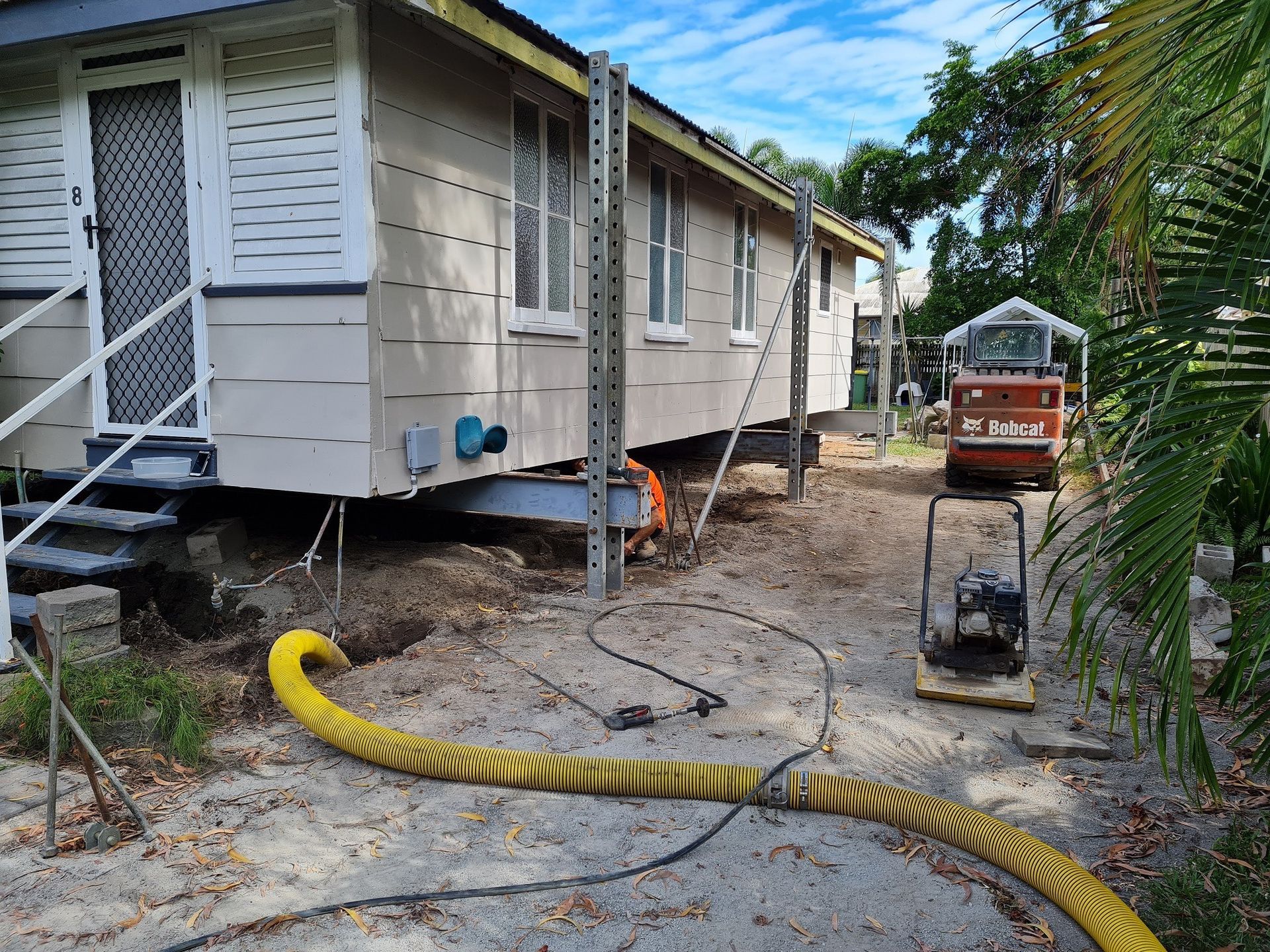 House Being Raised for Renovations, Machinery, Yellow Hose and Dirt — Pro-Jax Pty Ltd in Bohle, QLD