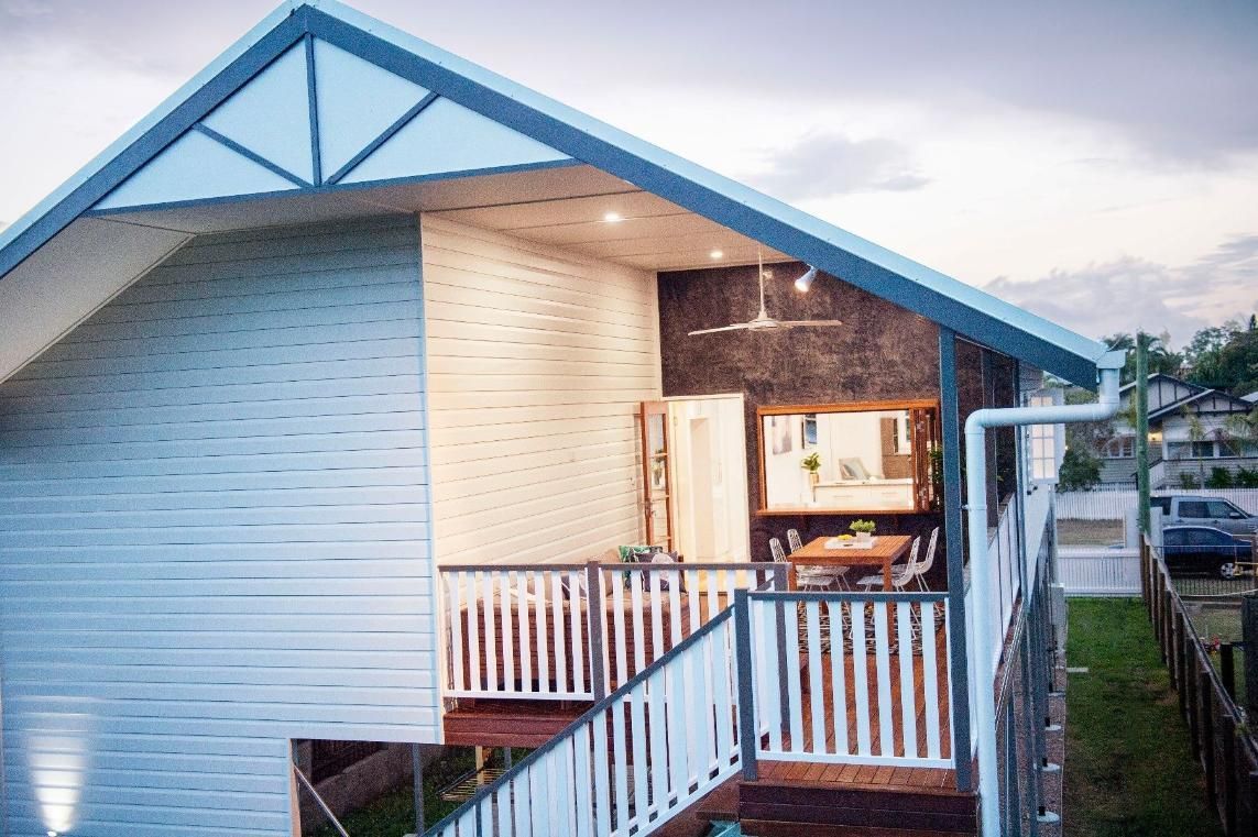 A White House With a Blue Roof and Stairs Leading Up to It — Pro-Jax Pty Ltd in Bohle, QLD