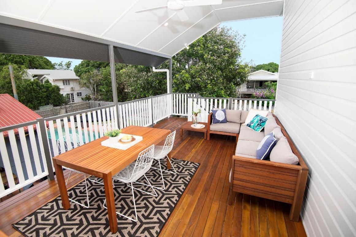 A Wooden Deck With a Couch, Table and Chairs on It — Pro-Jax Pty Ltd in Bohle, QLD