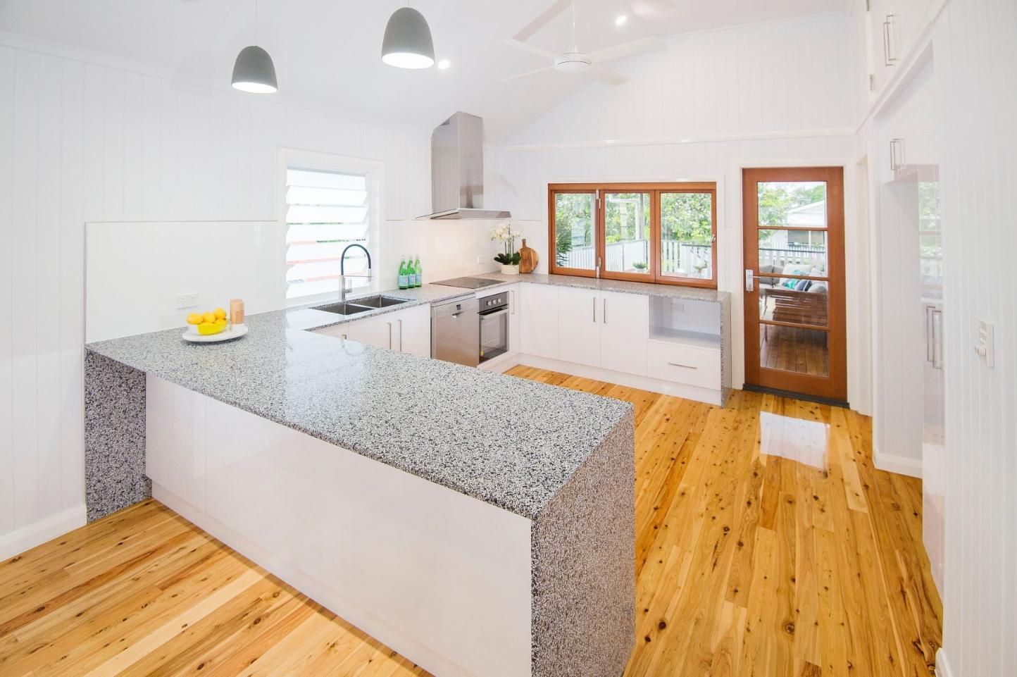 A Kitchen With Granite Counter Tops and Wooden Floors — Pro-Jax Pty Ltd in Bohle, QLD