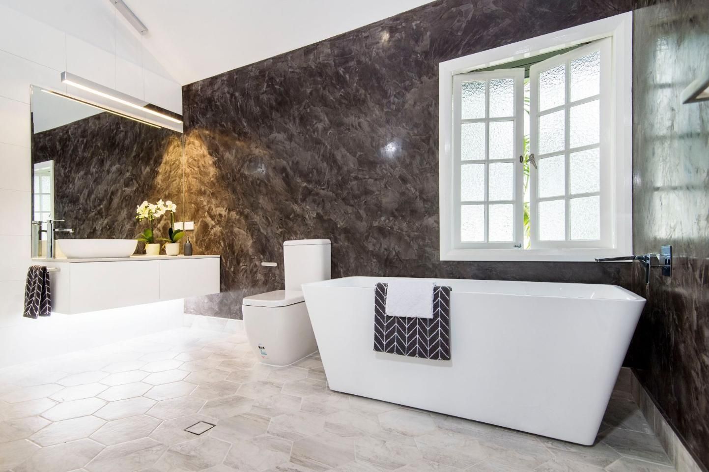 A Bathroom With a Tub, Toilet, Sink and Mirror — Pro-Jax Pty Ltd in Bohle, QLD