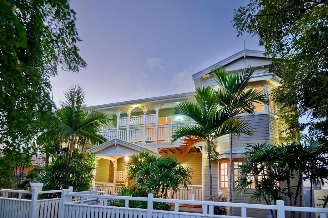 A Large House With a White Fence and Trees in Front of It — Pro-Jax Pty Ltd in Bohle, QLD