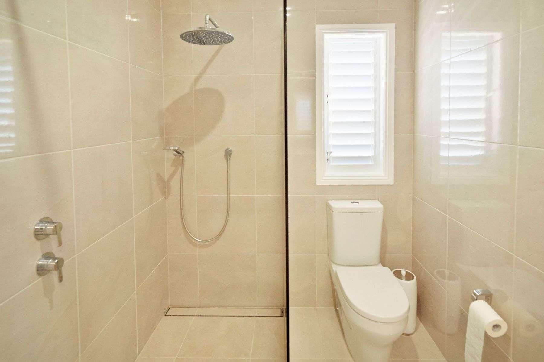 A Bathroom With a Toilet, Shower and Window — Pro-Jax Pty Ltd in Bohle, QLD