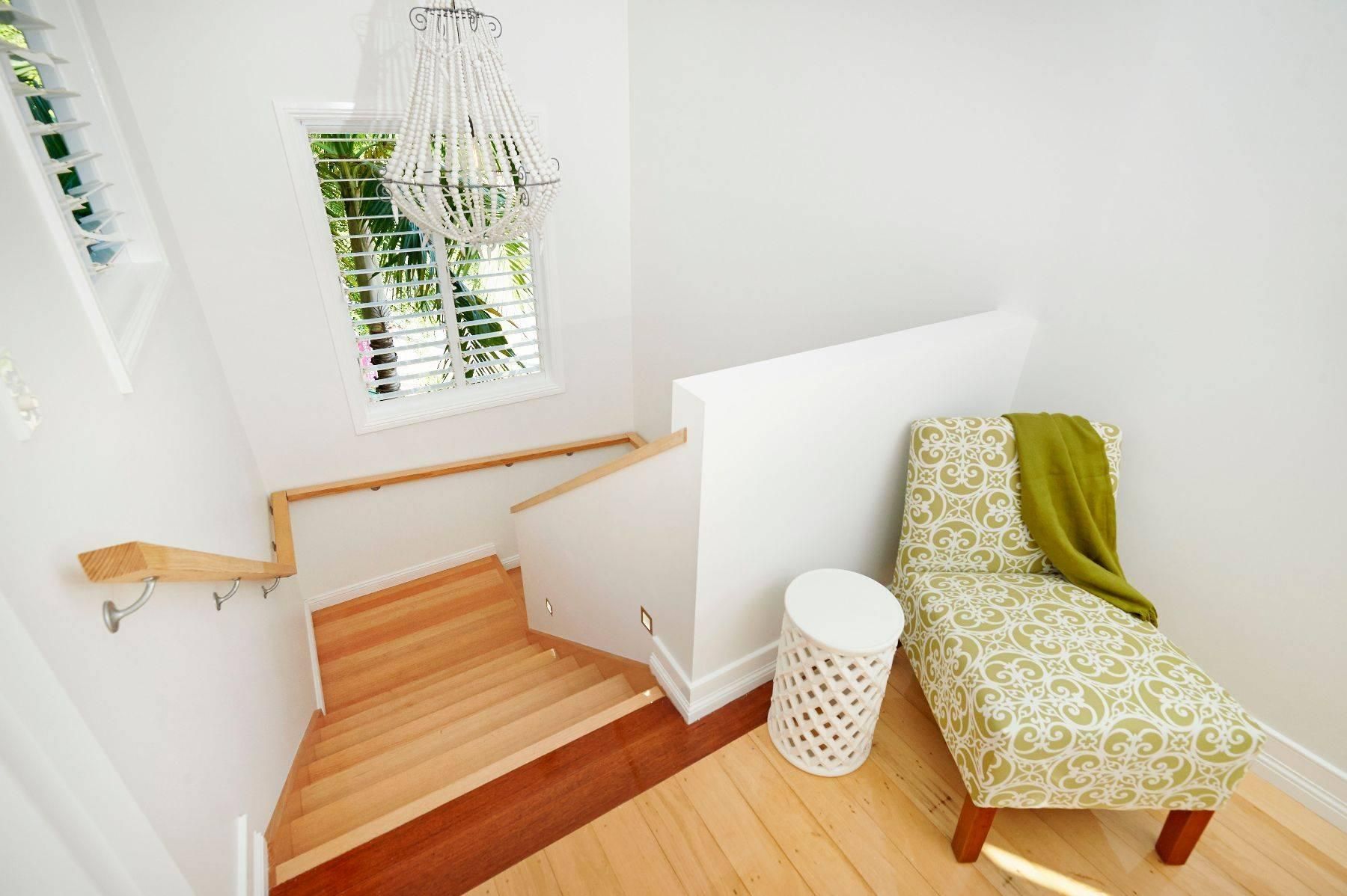 A Chair With a Green Blanket on It is Sitting Next to a Wooden Staircase — Pro-Jax Pty Ltd in Bohle, QLD