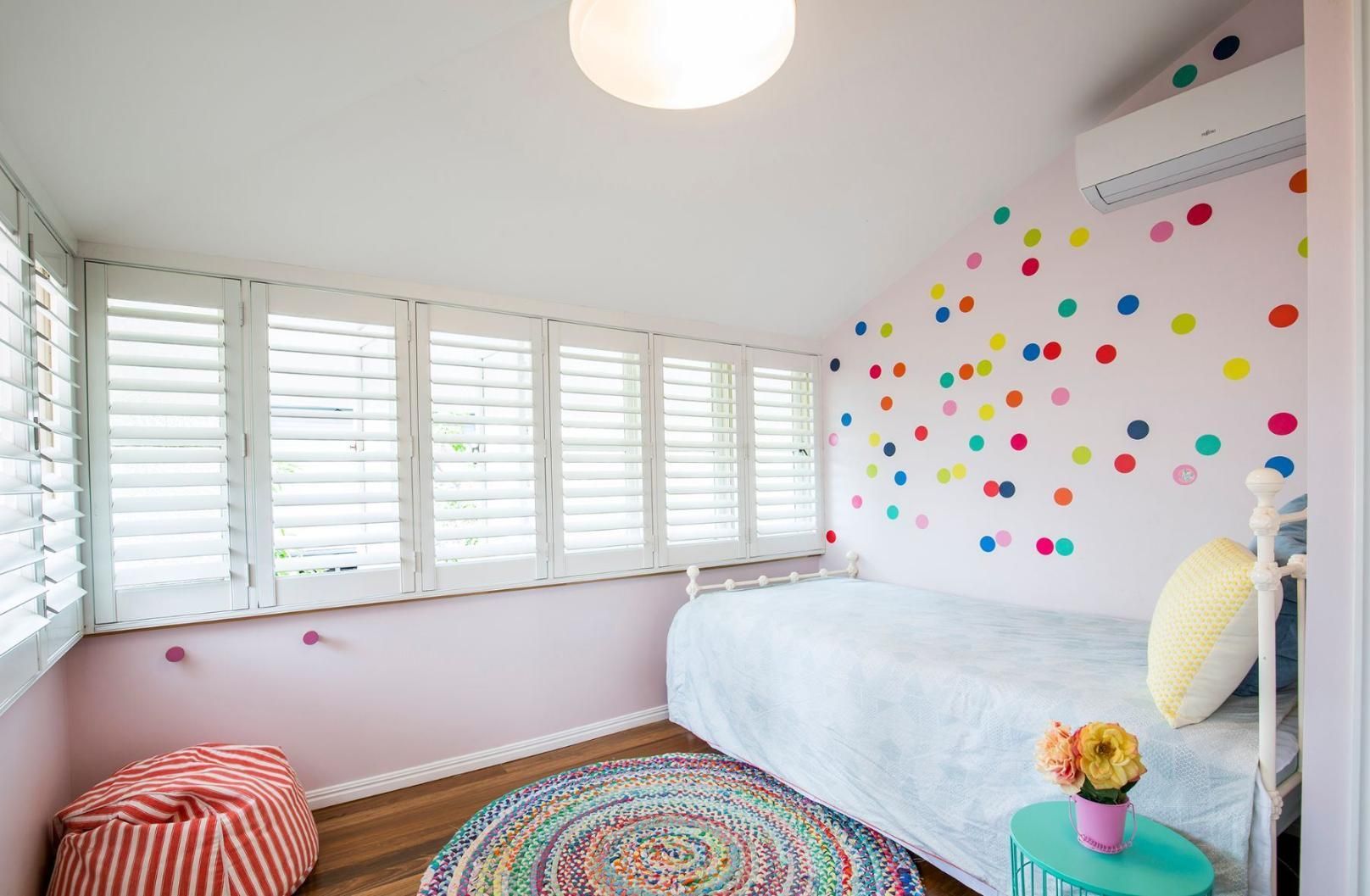 A Bedroom With a Bed, Ottoman, Rug and Shutters — Pro-Jax Pty Ltd in Bohle, QLD