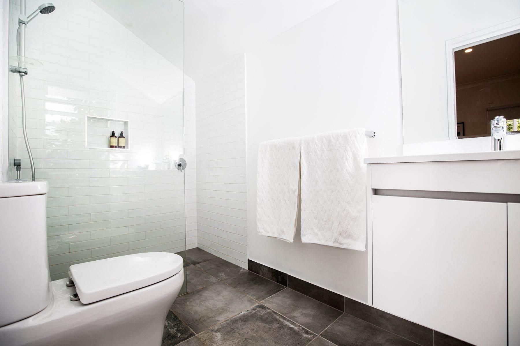 A Bathroom With a Toilet, Sink, Mirror and Shower — Pro-Jax Pty Ltd in Bohle, QLD