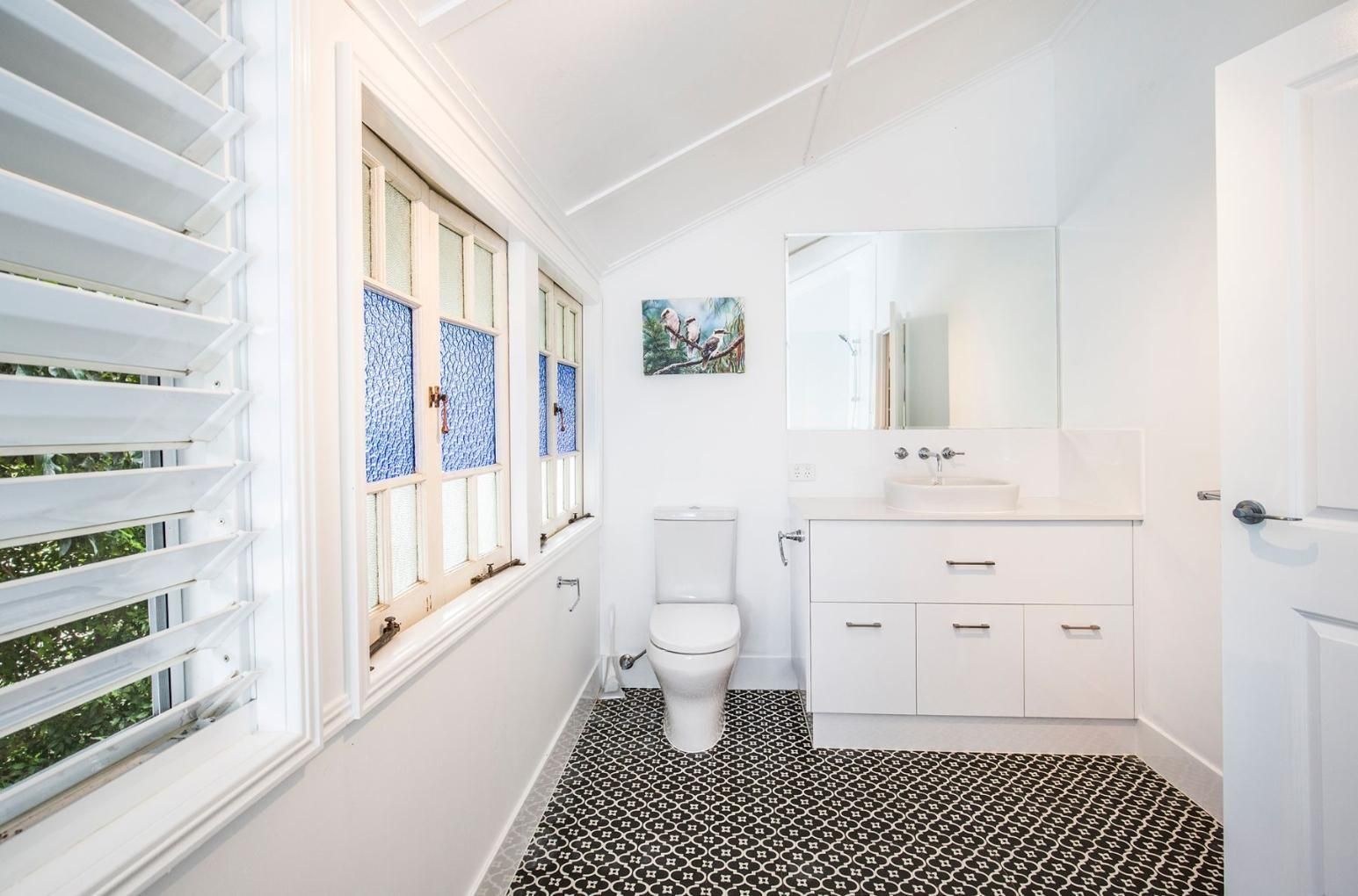 A Bathroom With a Toilet , Sink , Mirror and Window — Pro-Jax Pty Ltd in Bohle, QLD
