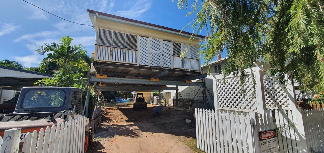 A House With a White Picket Fence and a Truck Parked in Front of It  — Pro-Jax Pty Ltd in Bohle, QLD