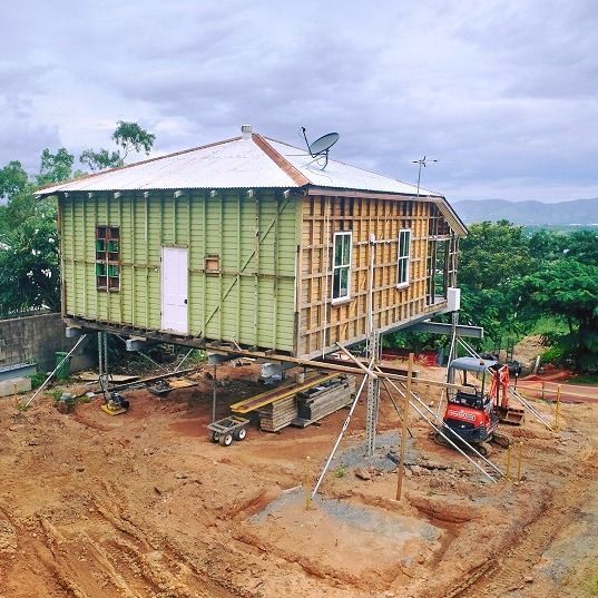 A Green House is Being Built on Stilts in a Dirt Field — Pro-Jax Pty Ltd in Bohle, QLD
