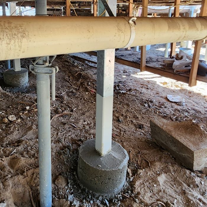 A Pipe is Sitting on Top of a Concrete Base in the Dirt — Pro-Jax Pty Ltd in Bohle, QLD