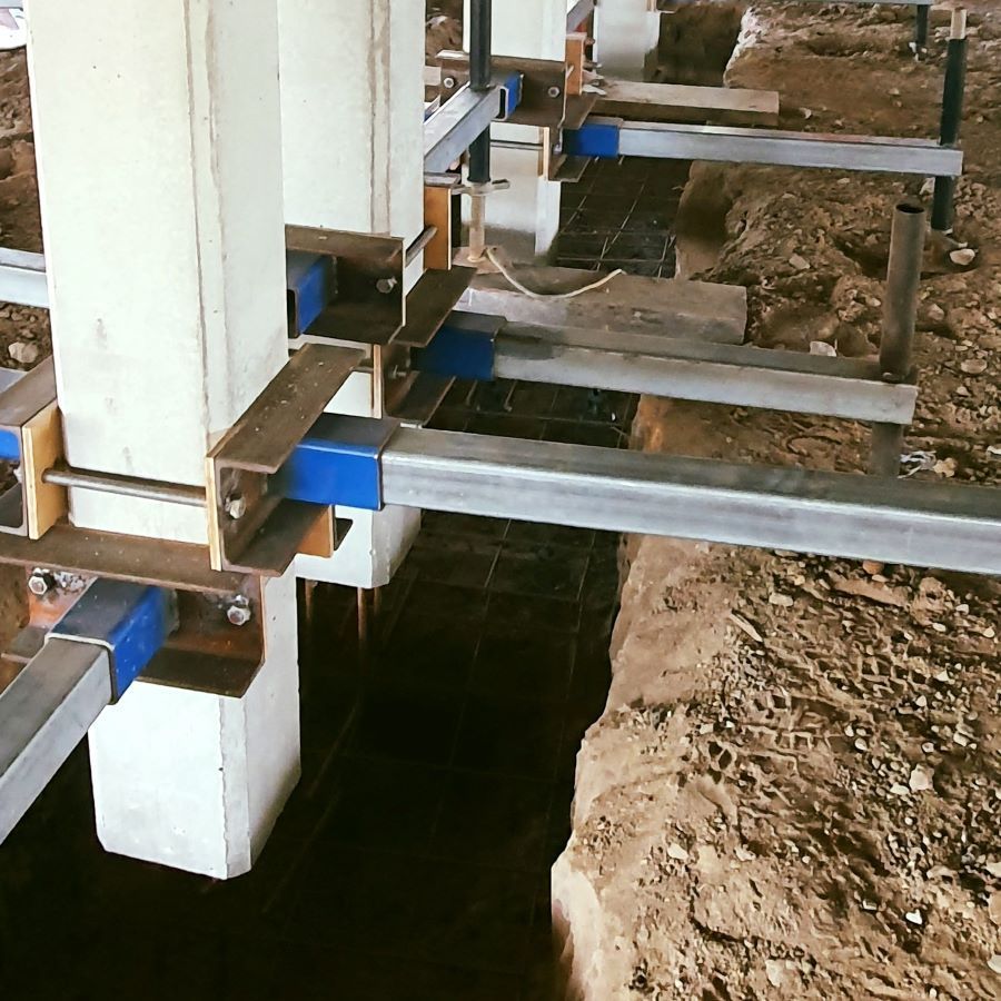 A Row of Concrete Pillars Are Being Supported by Metal Beams — Pro-Jax Pty Ltd in Bohle, QLD
