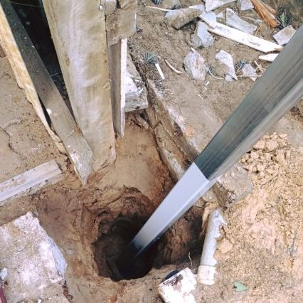 A Metal Pole is Sticking Out of a Hole in the Ground — Pro-Jax Pty Ltd in Bohle, QLD
