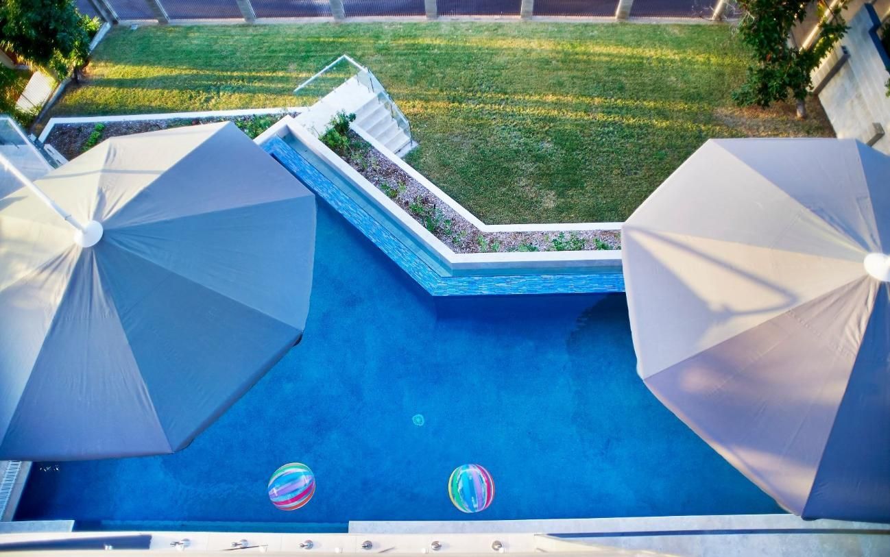 An Aerial View of a Swimming Pool With Umbrellas and Beach Balls — Pro-Jax Pty Ltd in Bohle, QLD