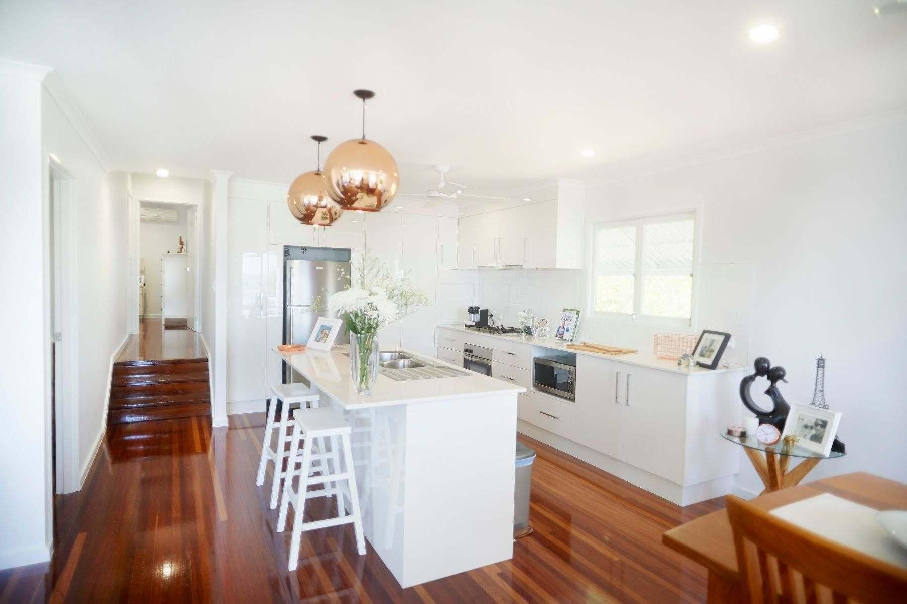 A Kitchen With White Cabinets and Wooden Floors — Pro-Jax Pty Ltd in Bohle, QLD
