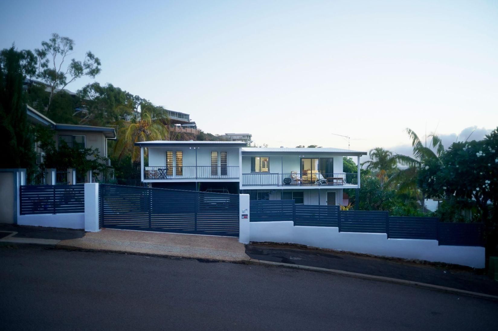 A Large White House With a Blue Fence in Front of It — Pro-Jax Pty Ltd in Bohle, QLD