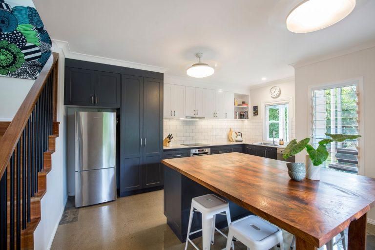 A Kitchen With a Large Wooden Table and Stools and a Stainless Steel Refrigerator — Pro-Jax Pty Ltd in Bohle, QLD