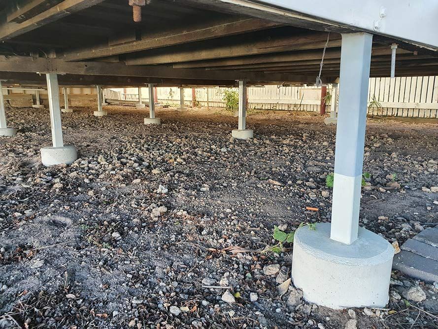 Gray House Foundation Supported by Concrete Pillars on Dirt Ground — Pro-Jax Pty Ltd in Bohle, QLD