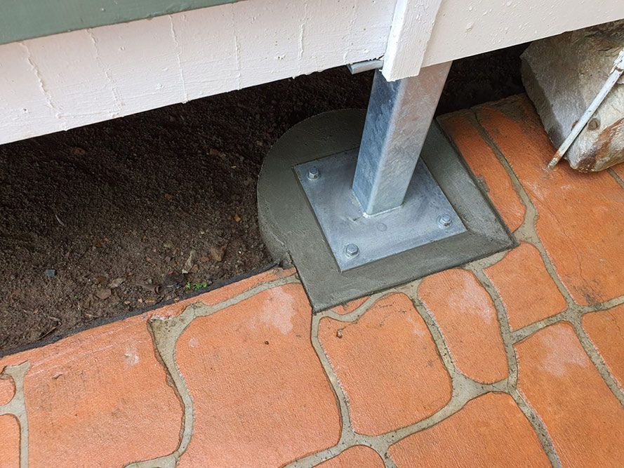 A Metal Post Anchored to a Concrete Base on Brick Pavers — Pro-Jax Pty Ltd in Bohle, QLD