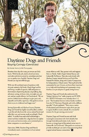 Chuck Siegel is standing next to two dogs in a park.