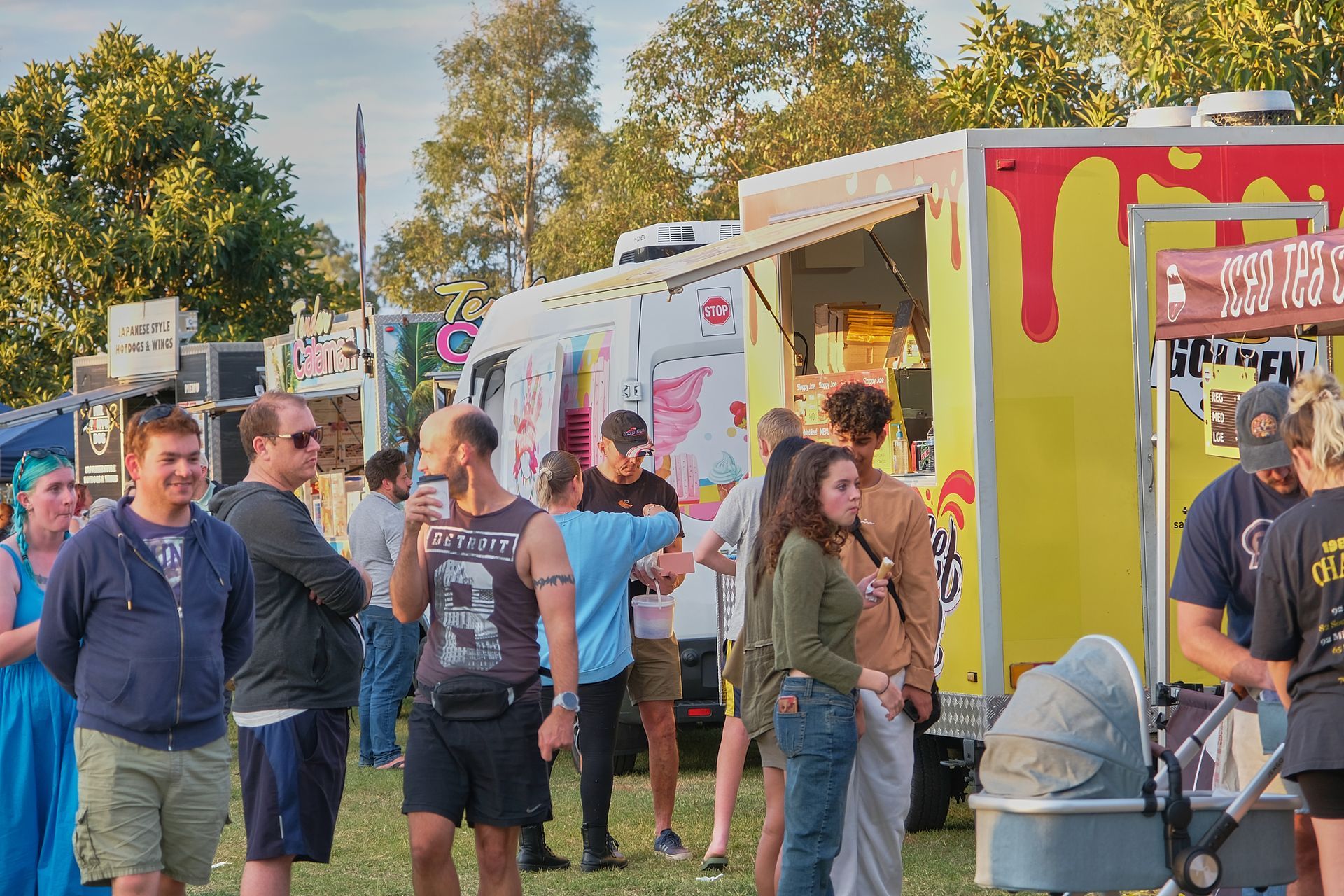 a group of people are standing in front of a food truck .