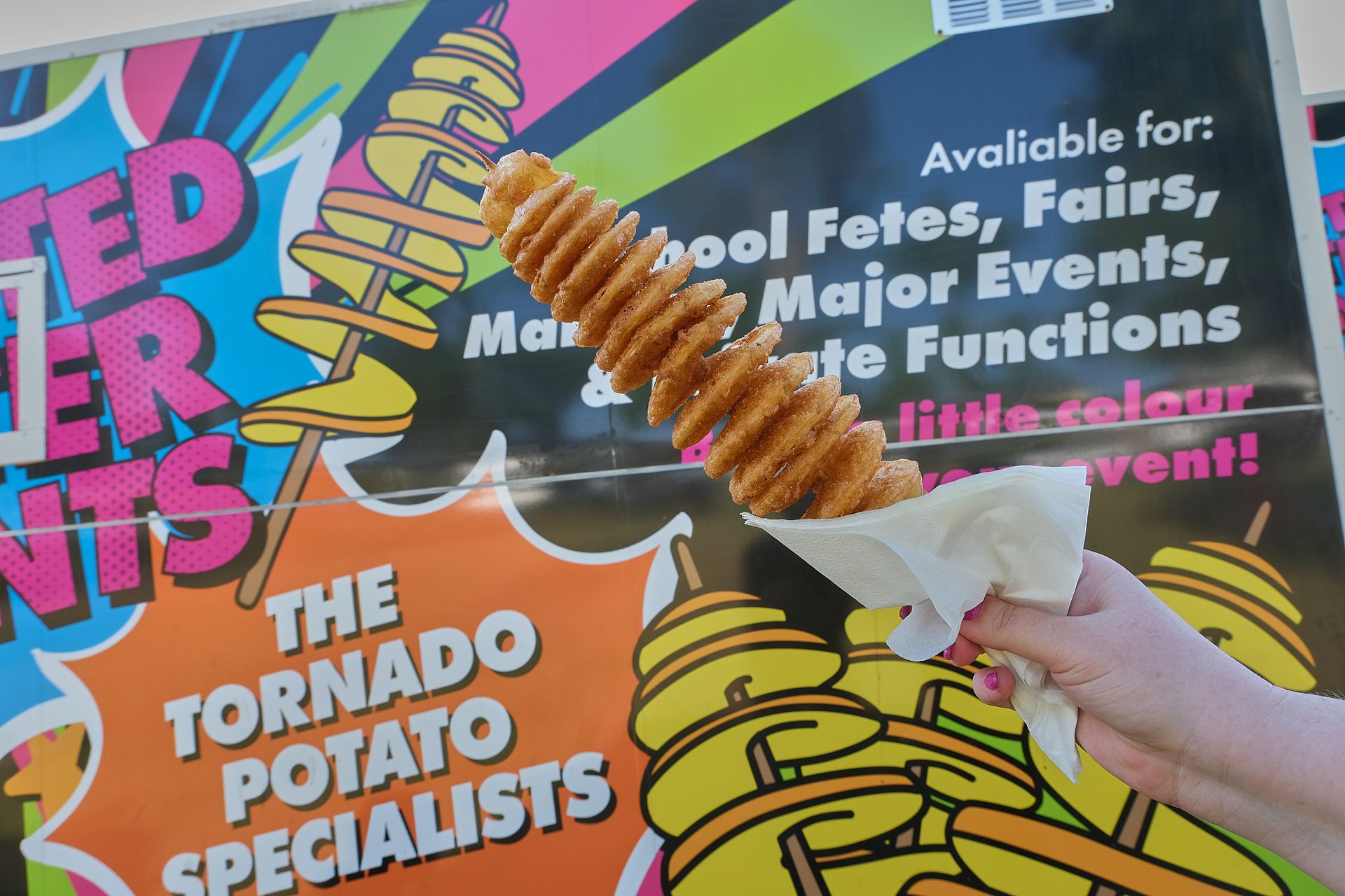 a person is holding a tornado potato on a stick