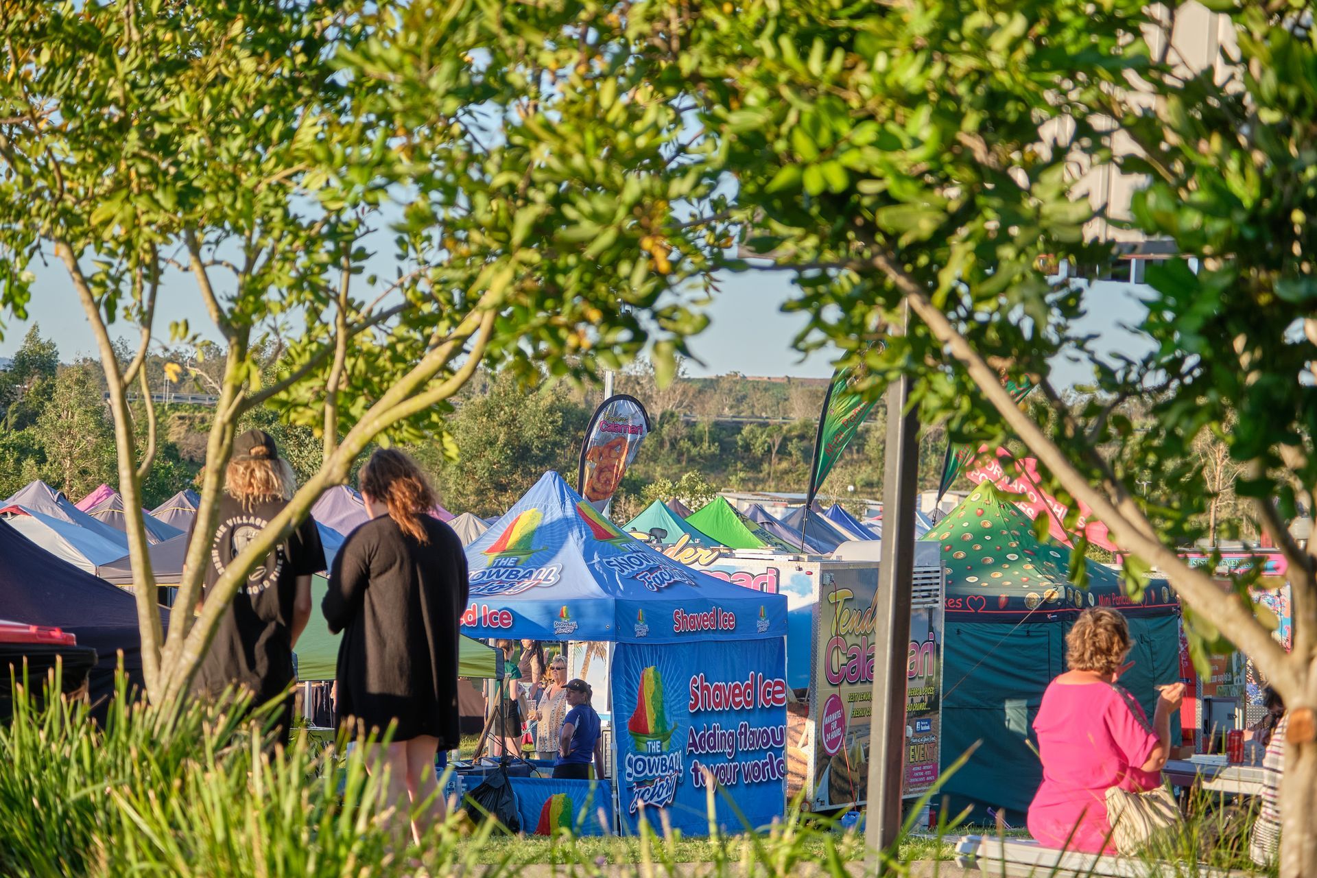 a group of people are standing in front of a colorful tent at a festival .