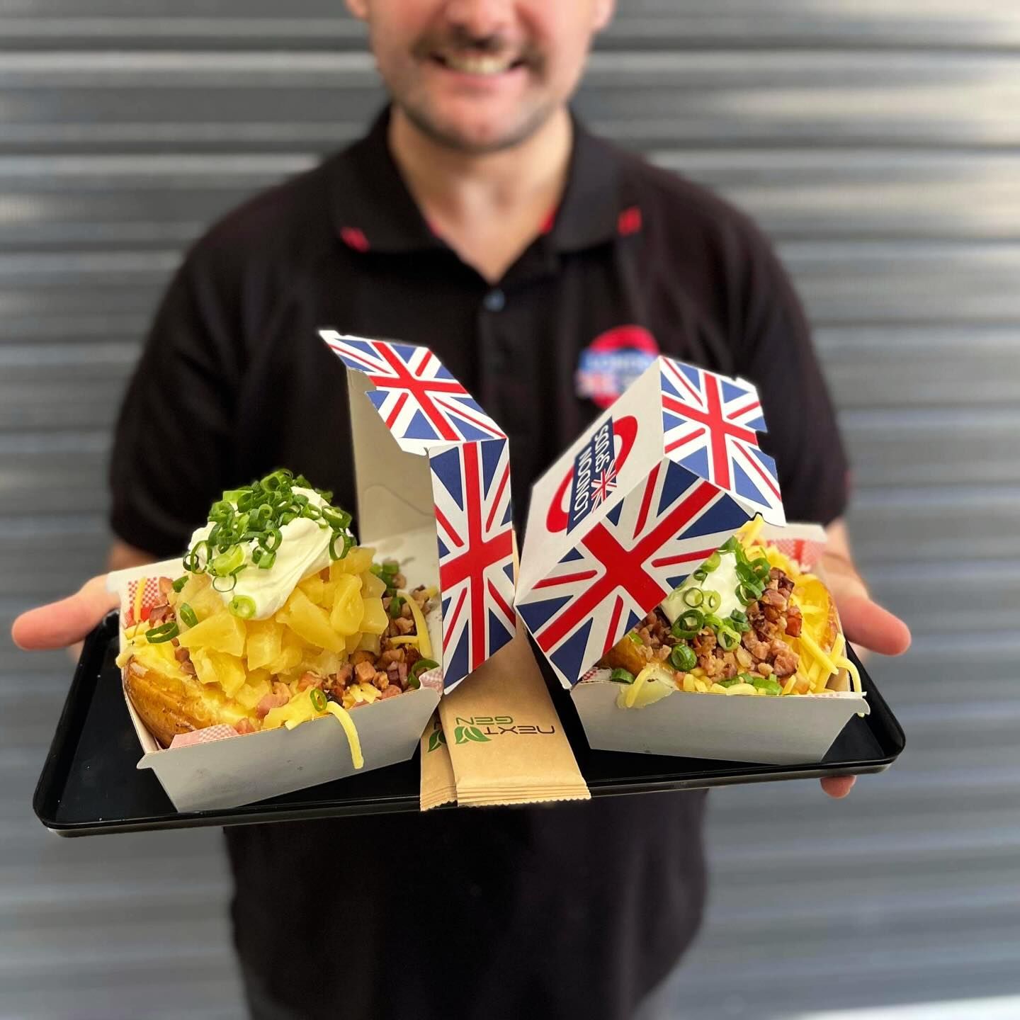 a man is holding a tray of food with a british flag on it