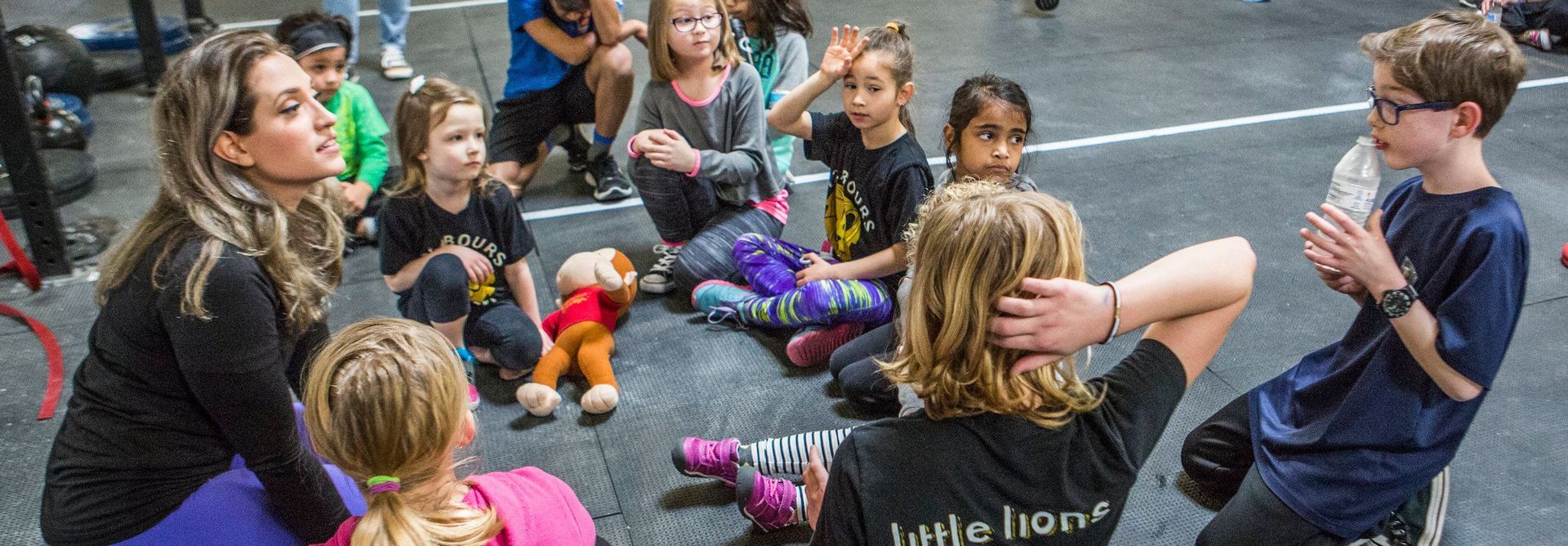 A group of children are sitting in a circle on the floor.