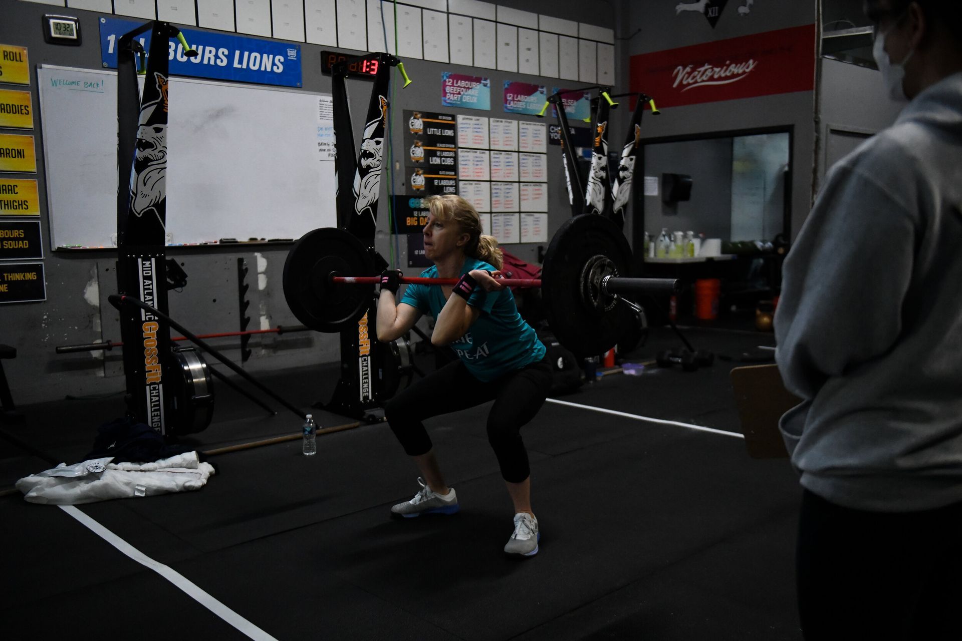 A woman squatting with a barbell in a gym