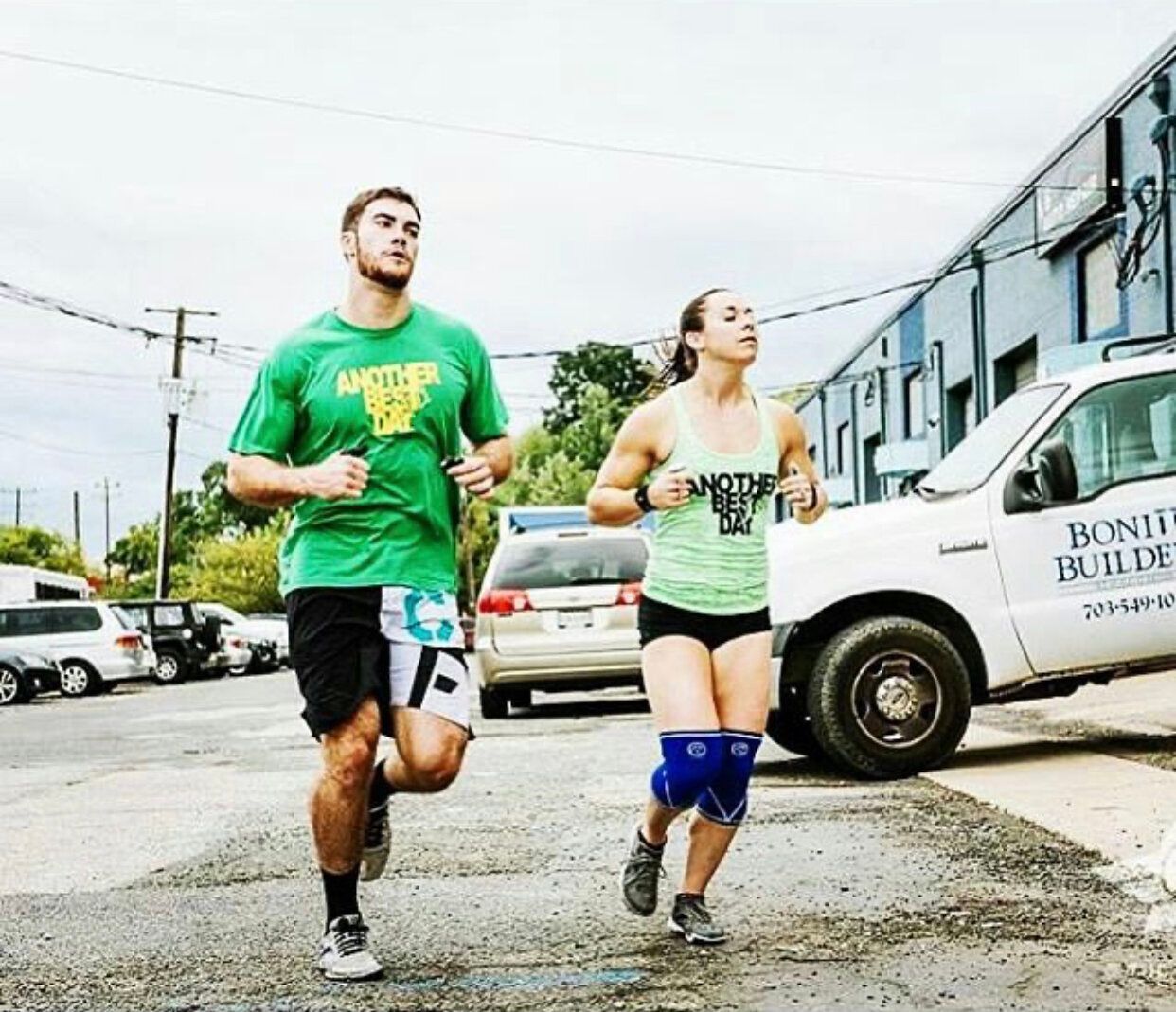 A man and a woman are running down a street.