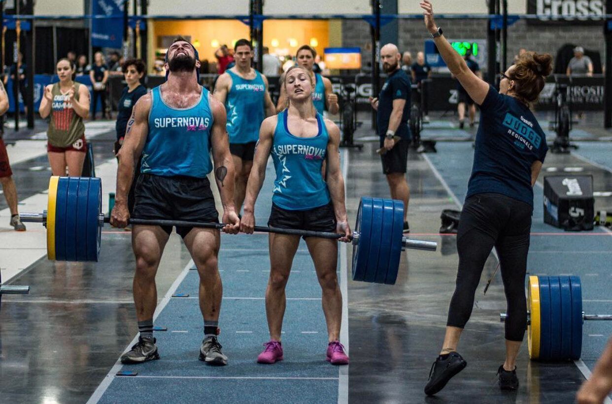 A group of people are lifting weights in a gym.