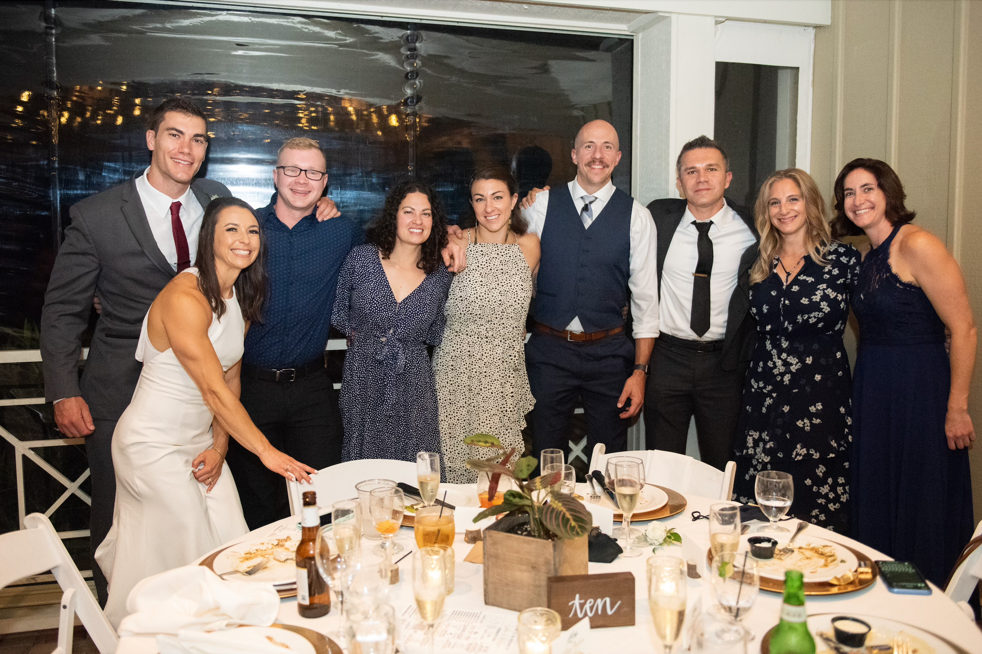 A group of people are posing for a picture at a wedding reception.