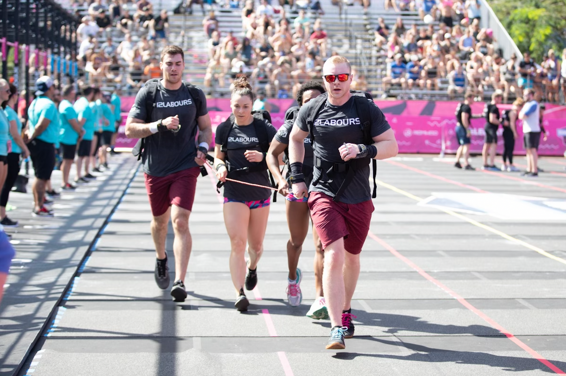 A group of people are running on a track in front of a crowd.