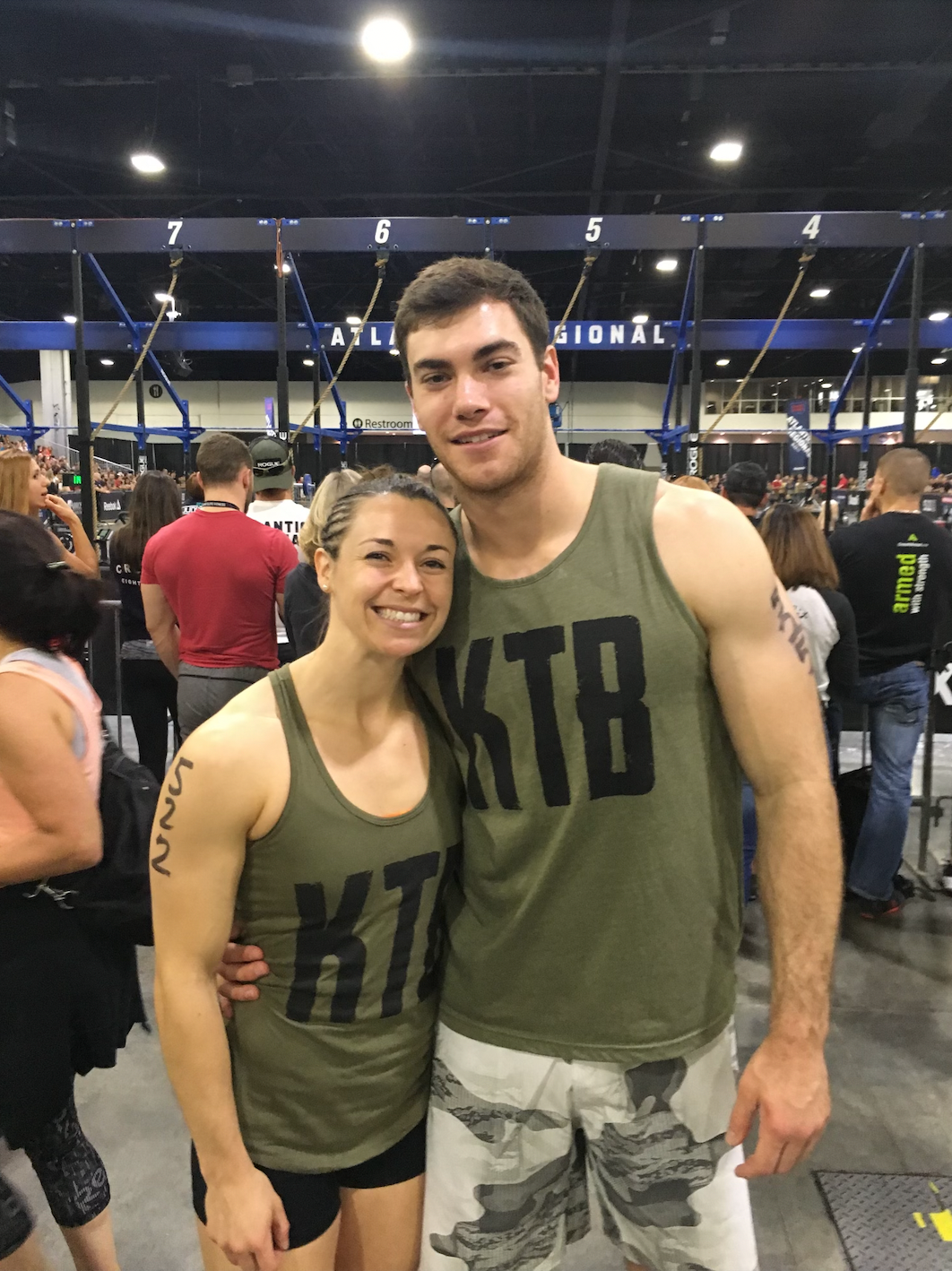 A man and a woman are posing for a picture while wearing ktb tank tops