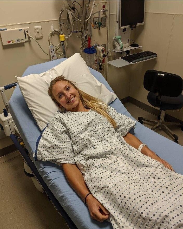 A woman in a hospital gown is laying in a hospital bed