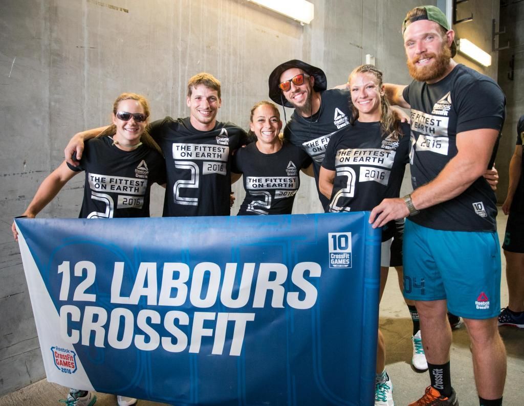 A group of people holding a blue banner that says 12 labours crossfit