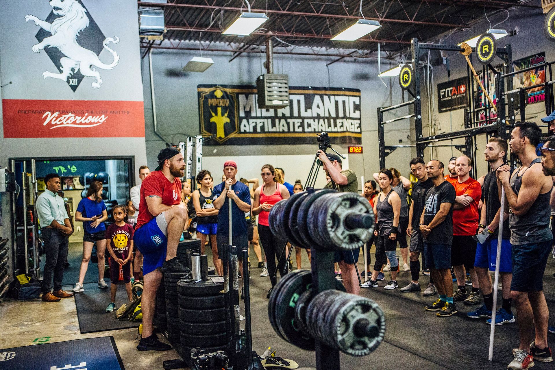 A group of people are standing in a gym talking to each other.