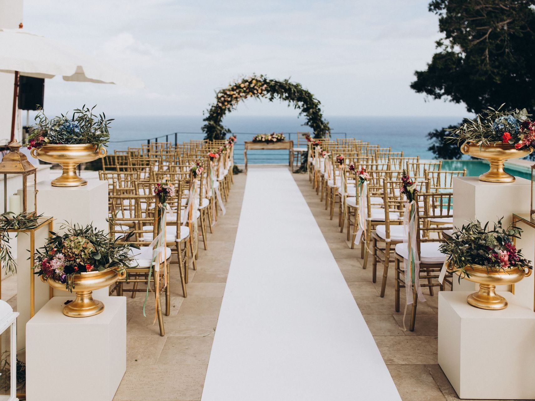 A wedding ceremony is taking place in front of the ocean.