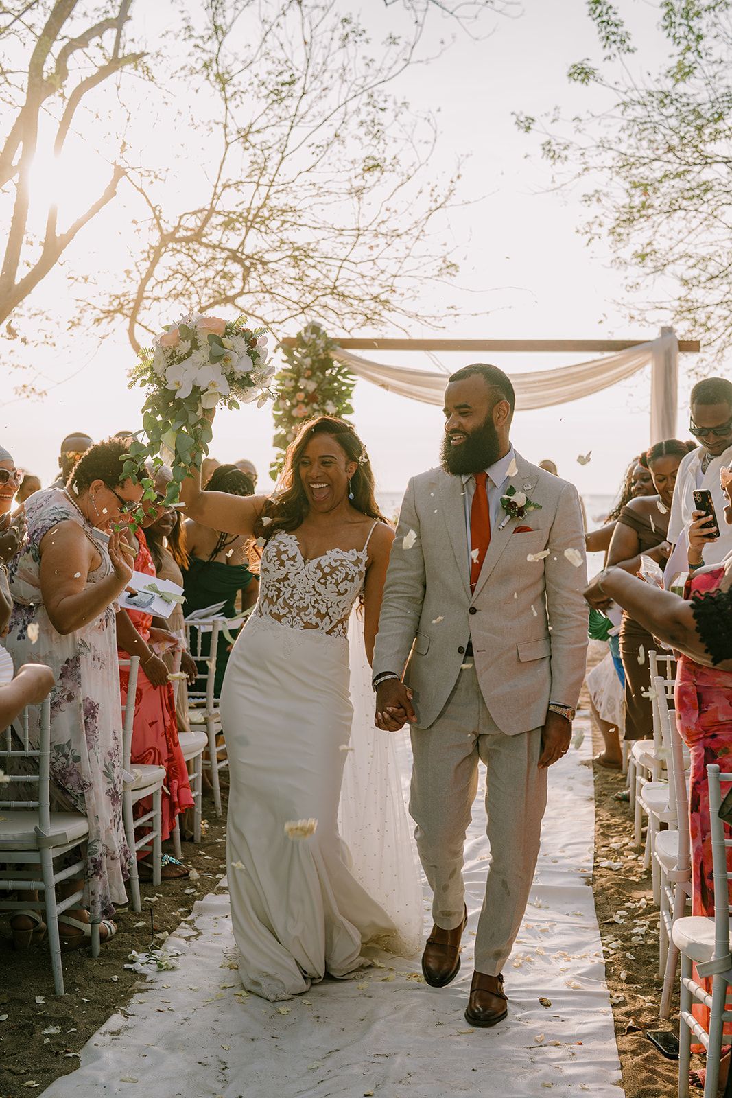 A bride and groom are walking down the aisle at their wedding holding hands.