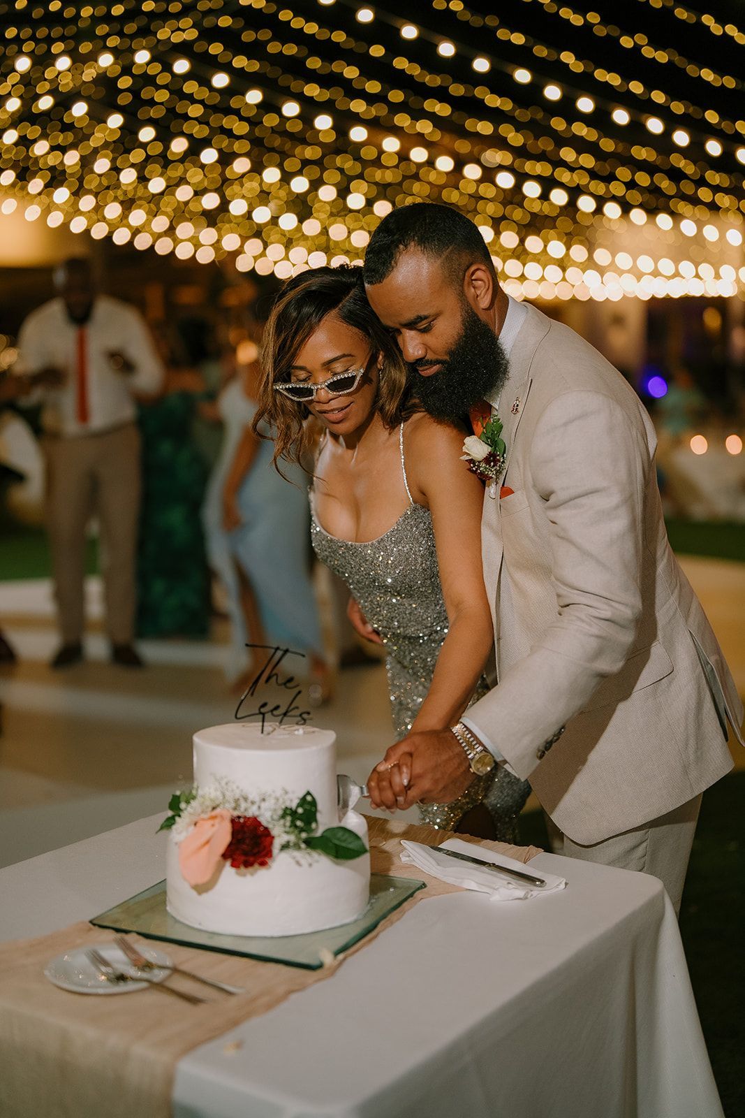 A bride and groom are cutting their wedding cake at their wedding reception.