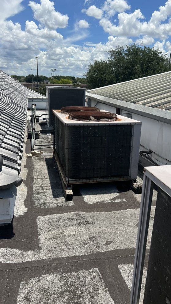 A large air conditioner is sitting on top of a roof.